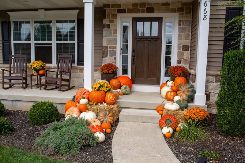 The Estate shot straight on with its rocking chairs, pumpkins running the full width of the porch and down the steps