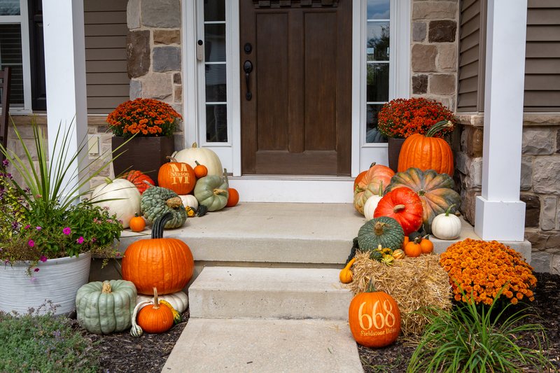The Harvest at step level, both pumpkin clusters flanking the door, a Mason pumpkin and a house-number pumpkin among them